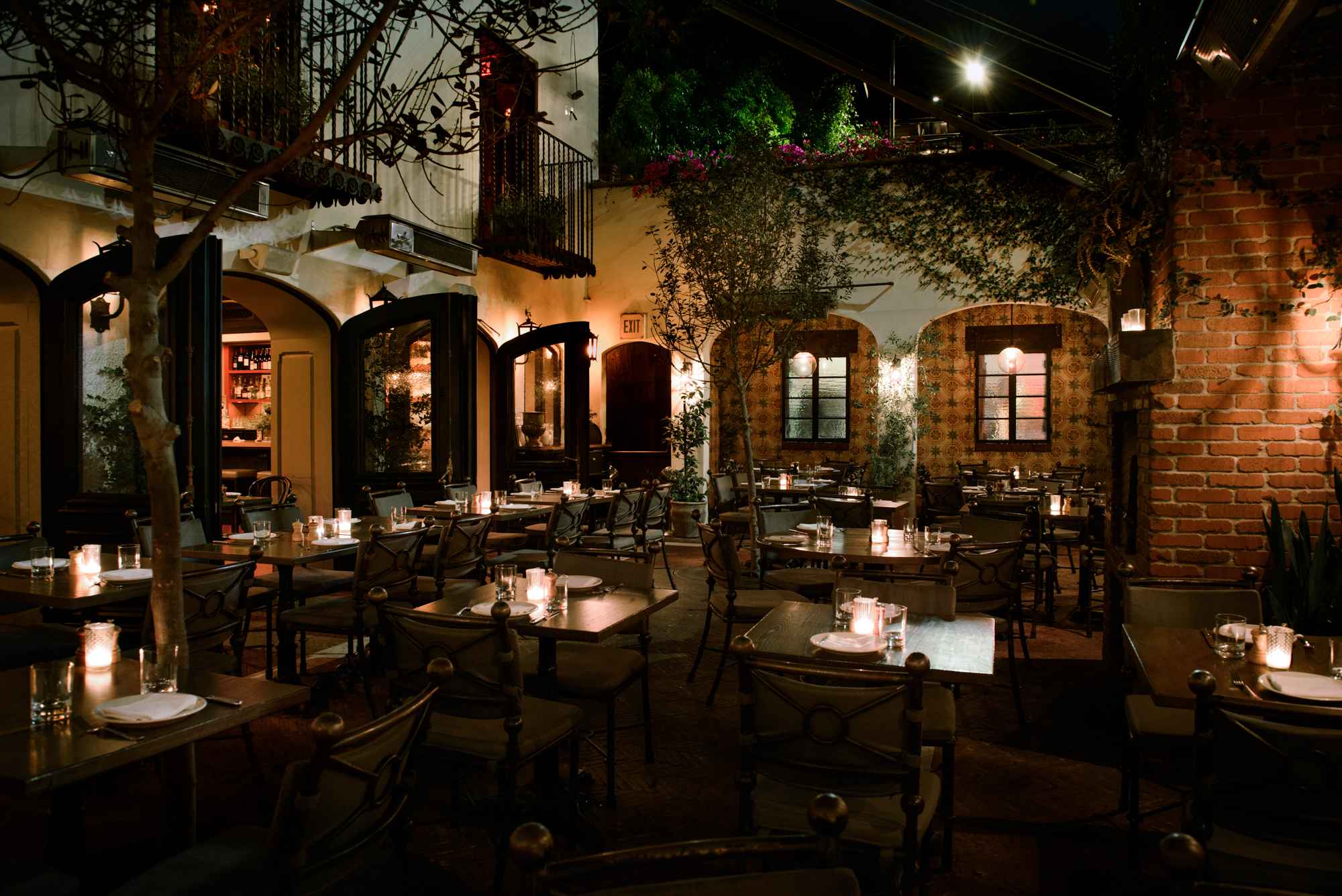 Vines and greenery cover the brick walls in the outdoor courtyard at A.O.C. in Los Angeles