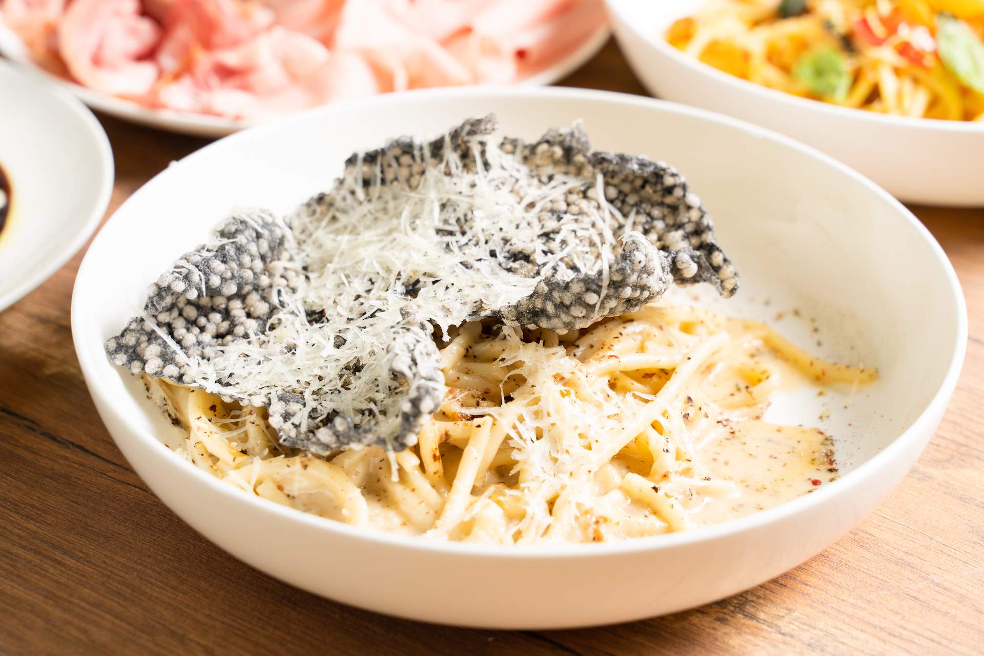 A pasta dish with a black cracker on top at NYC restaurant Mareluna