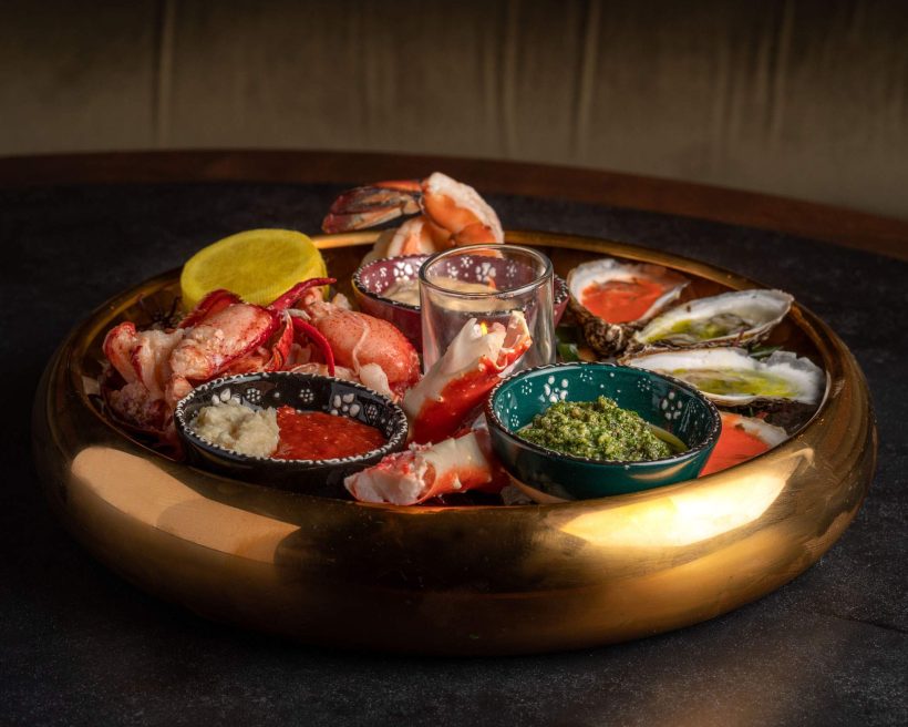 A circular gold tray topped with shellfish at Fioretta in Chicago