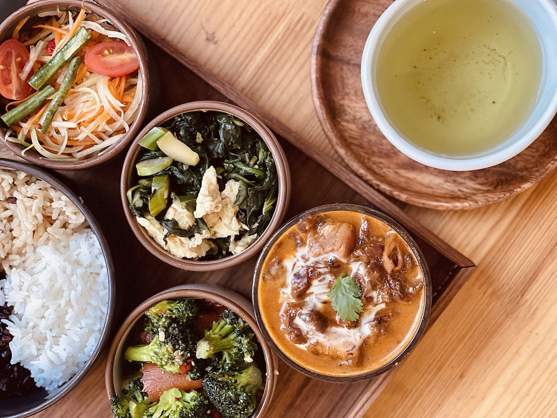 Several plated dishes such as vegetables and a Thai curry at SF restaurant Hed Verythai