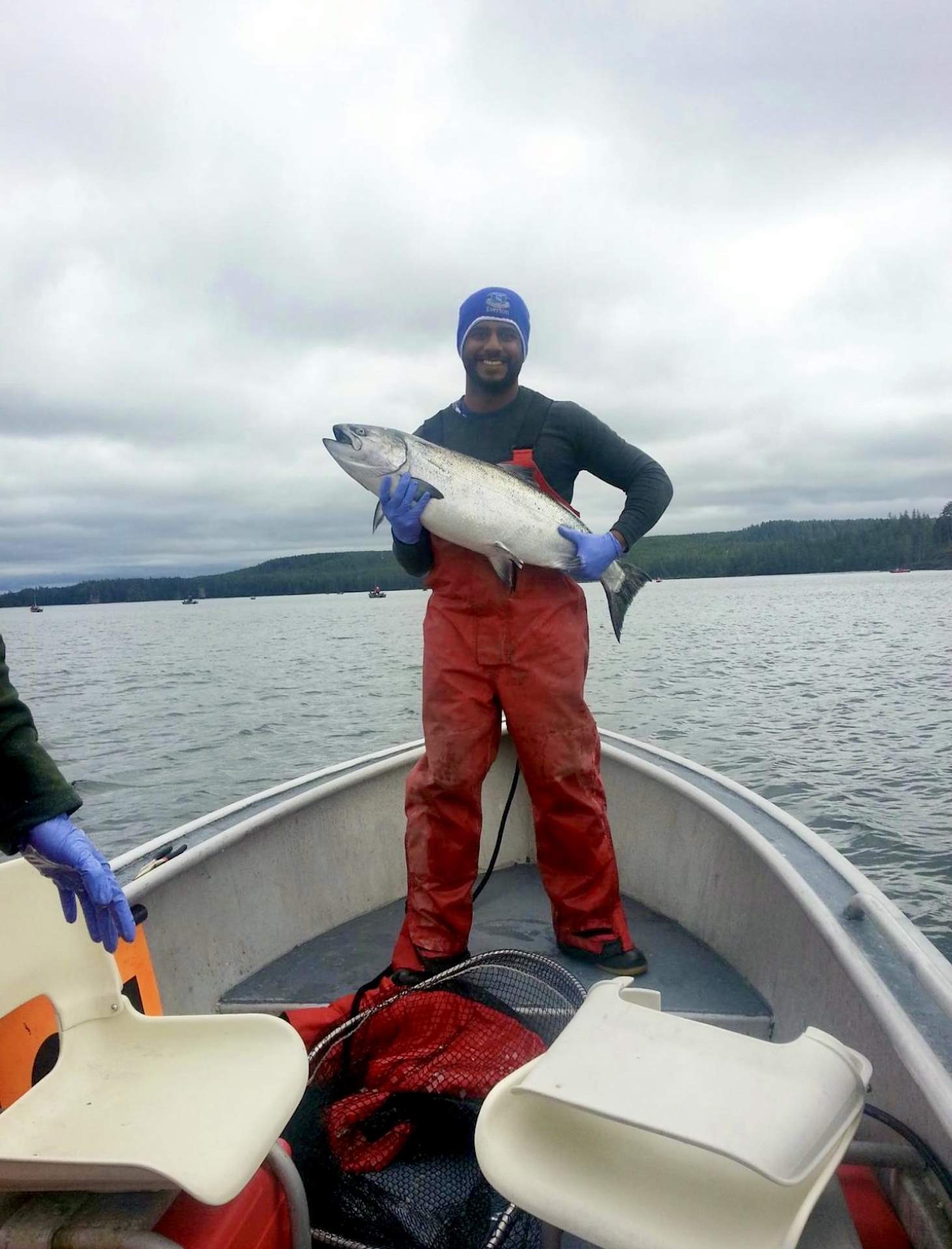 The chef Zaid Khan holding a fish in his hand while out fishing in Alaska