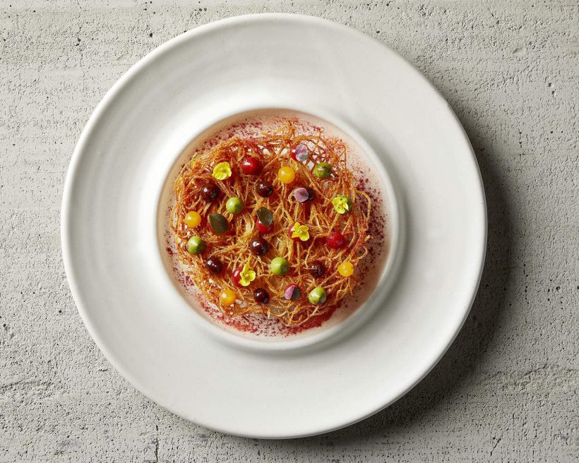 A colorful version of the Indian street food chaat at Chicago restaurant Indienne, served on a white plate.