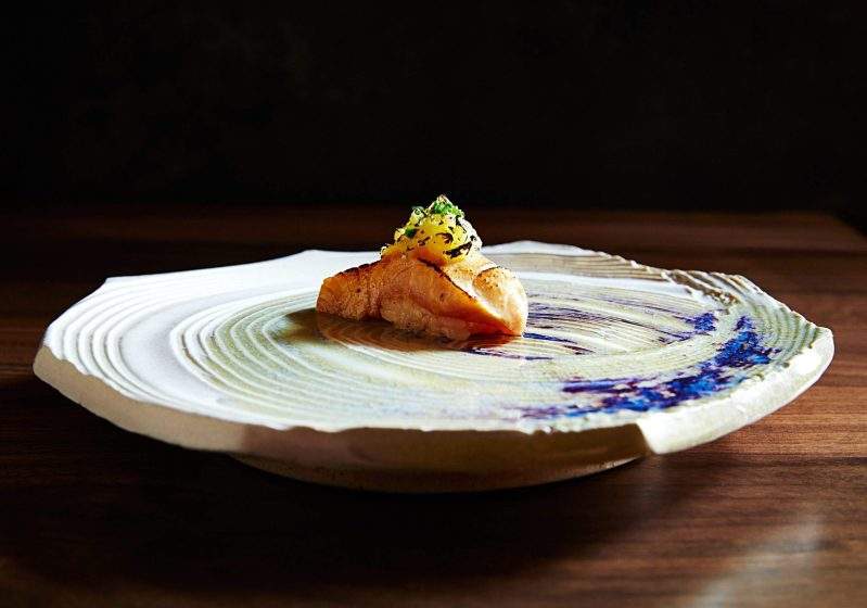 A white and purple plate with hamachi nigiri and spicy banana pepper mousse at o ya in Boston