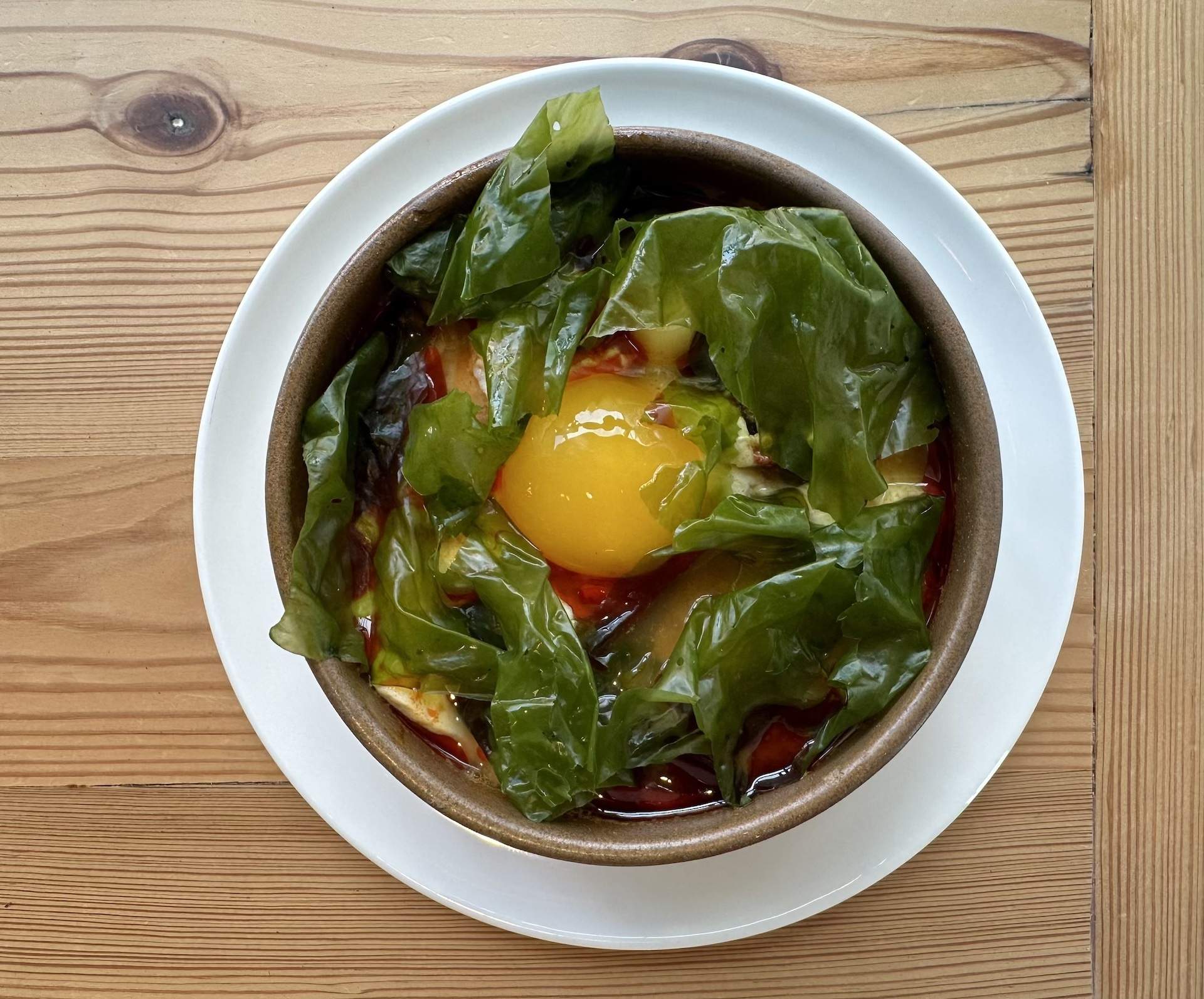 A lobster soup with a yellow yolk and green leaves at Chicago restaurant Parachute