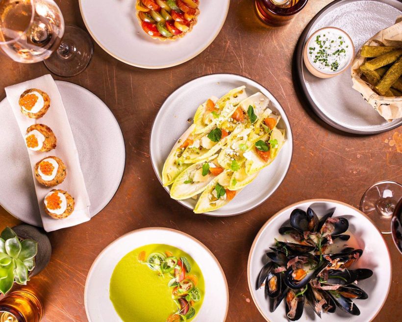 Different sets of white plates with food on it at NYC restaurant Print