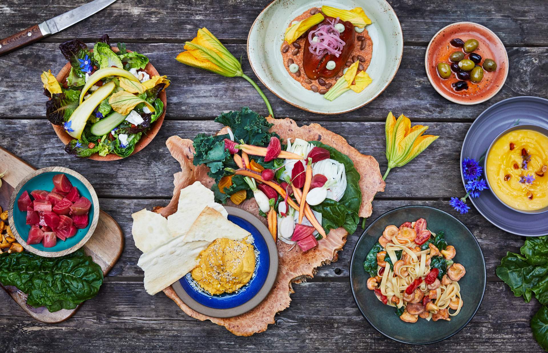 Colorful plates of food placed on a wooden table at SF restaurant Greens