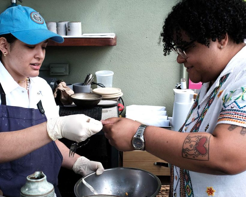 A food worker hands a plate to a guest