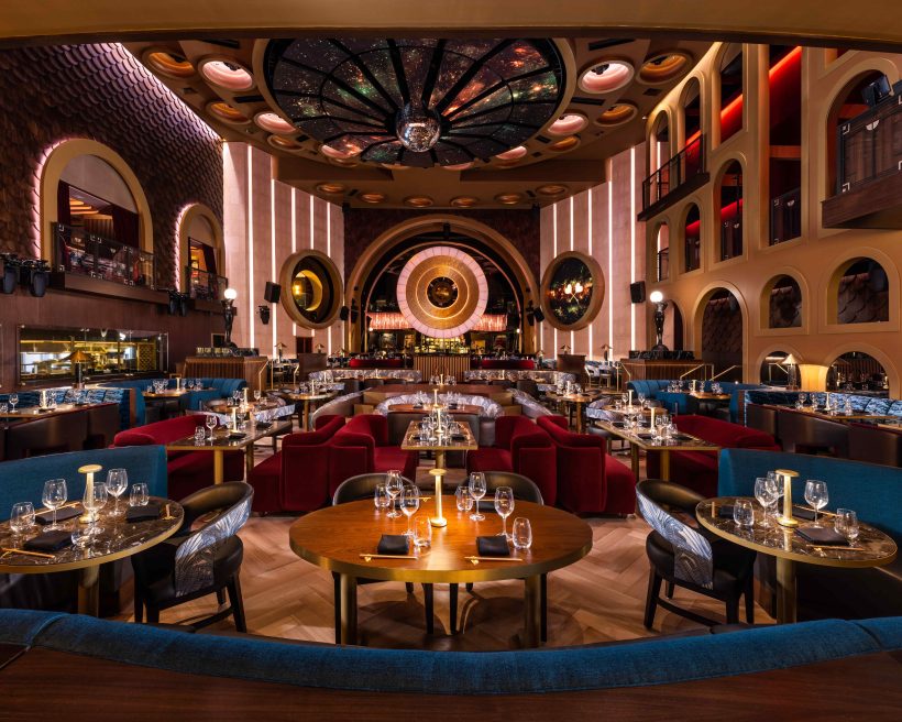 Blue and red velvet banquettes and soaring ceilings at Queen Miami Beach in Miami