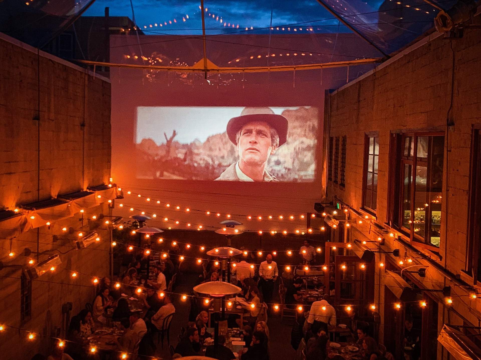 Fairy lights, outdoor seats, and a large screen playing a movie at Foreign Cinema in San Francisco