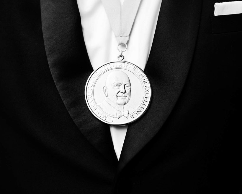 A silver James Beard medal on a black suit with a white shirt. This image serves as the hero image for a blog post announcing the winners of the 2023 James Beard Awards