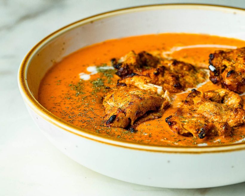 A close up of a plate full of the Indian curry butter chicken at NYC restaurant GupShup.