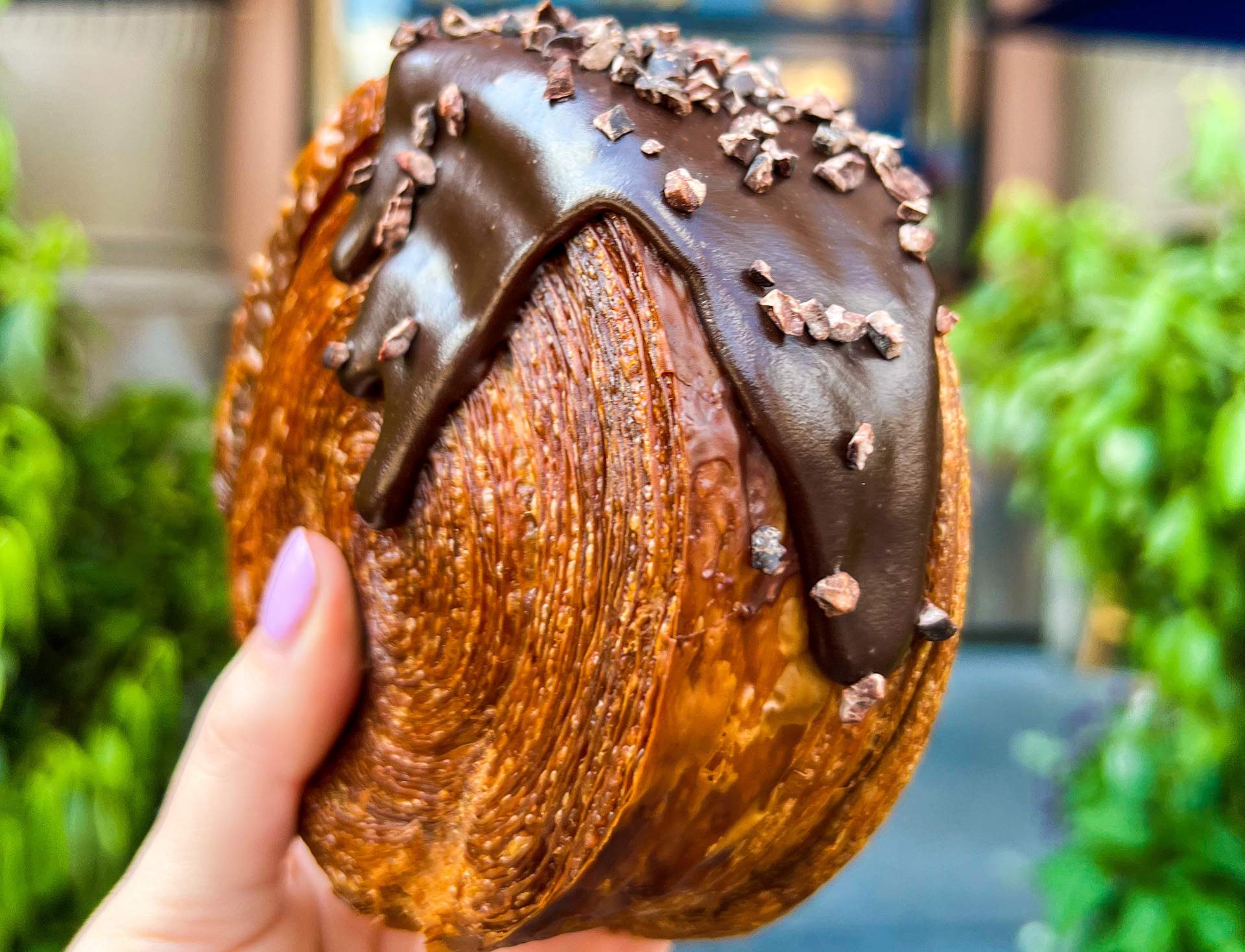 A close up of a spiral croissant from NYC restaurant Lafayette featuring a chocolate glaze.