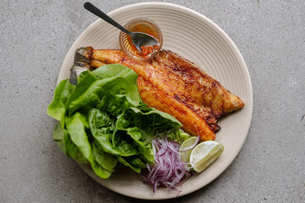 Grilled fish alongside lettuce, red onions, and lime at ATLA Venice in Los Angeles