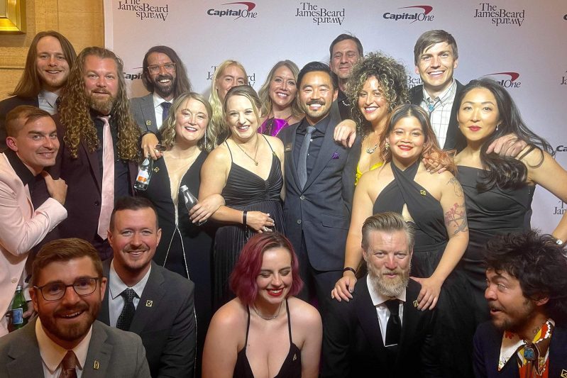 A group of people in black tie gather together for a photo.