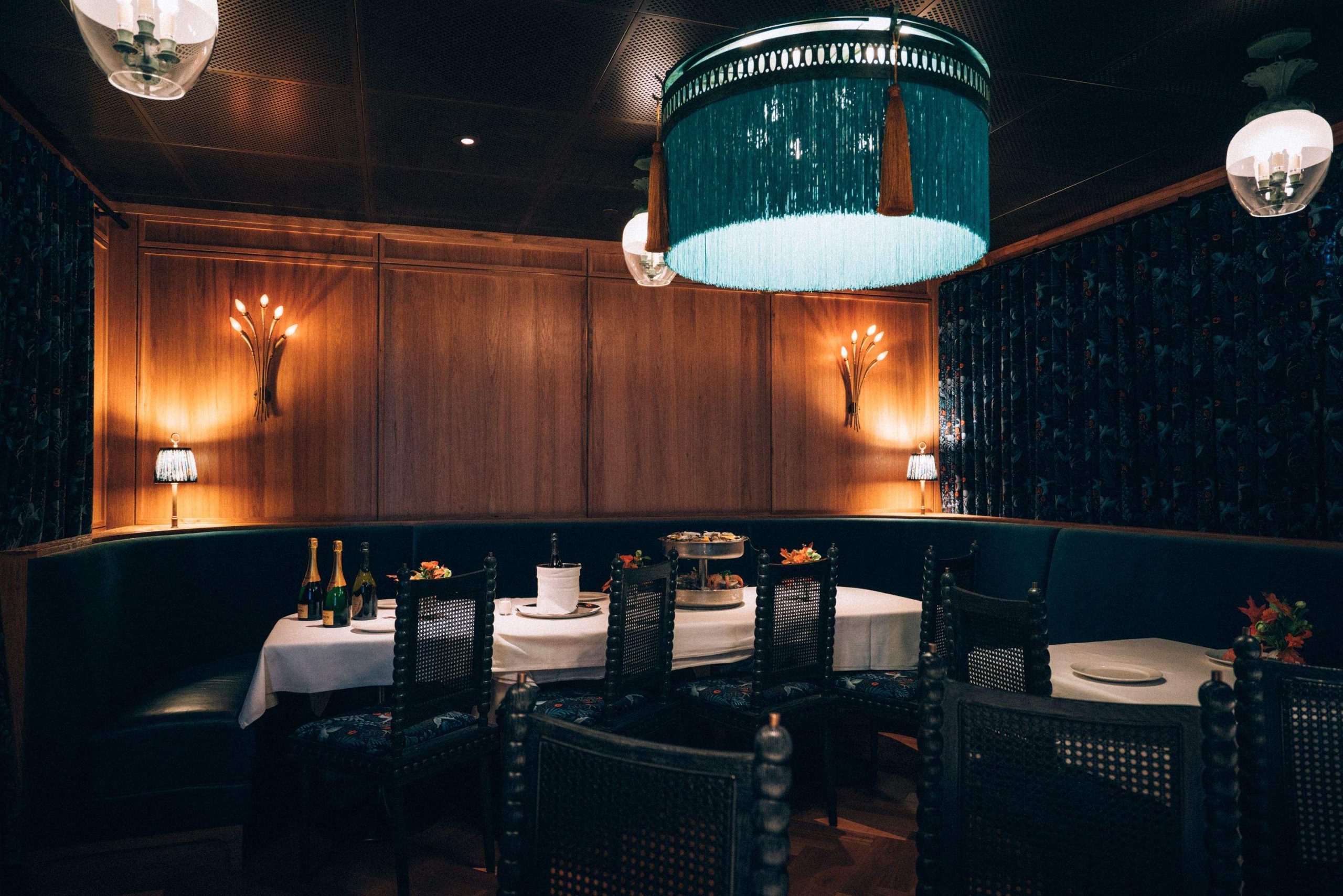 A tasseled blue light fixture and blue curtains make up the private dining room at Miller & Lux in San Francisco