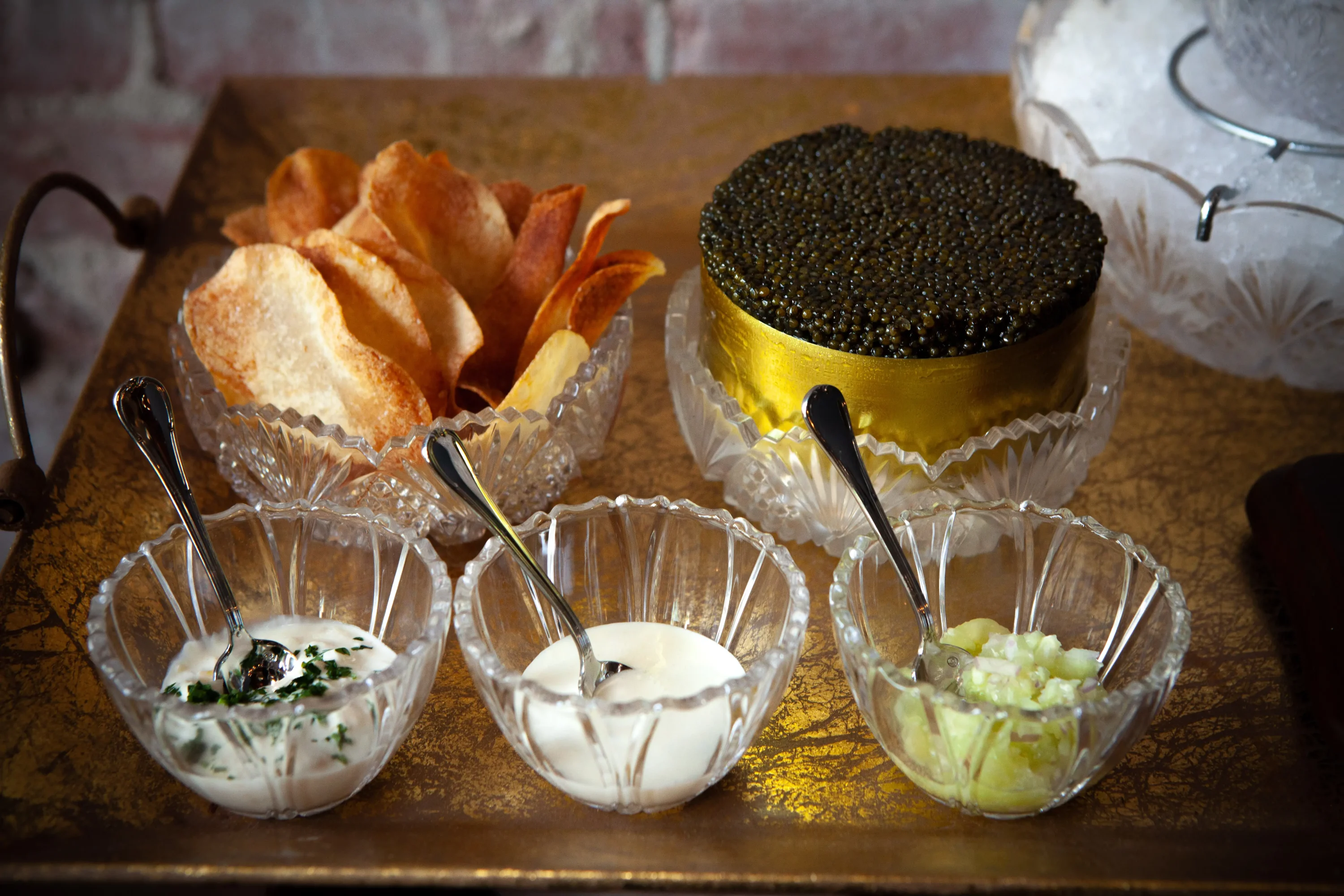 A bowl of caviar, a bowl of chips, and bowls of three dips at pasjoli, one of the most romantic restaurants in Los Angeles available on OpenTable.