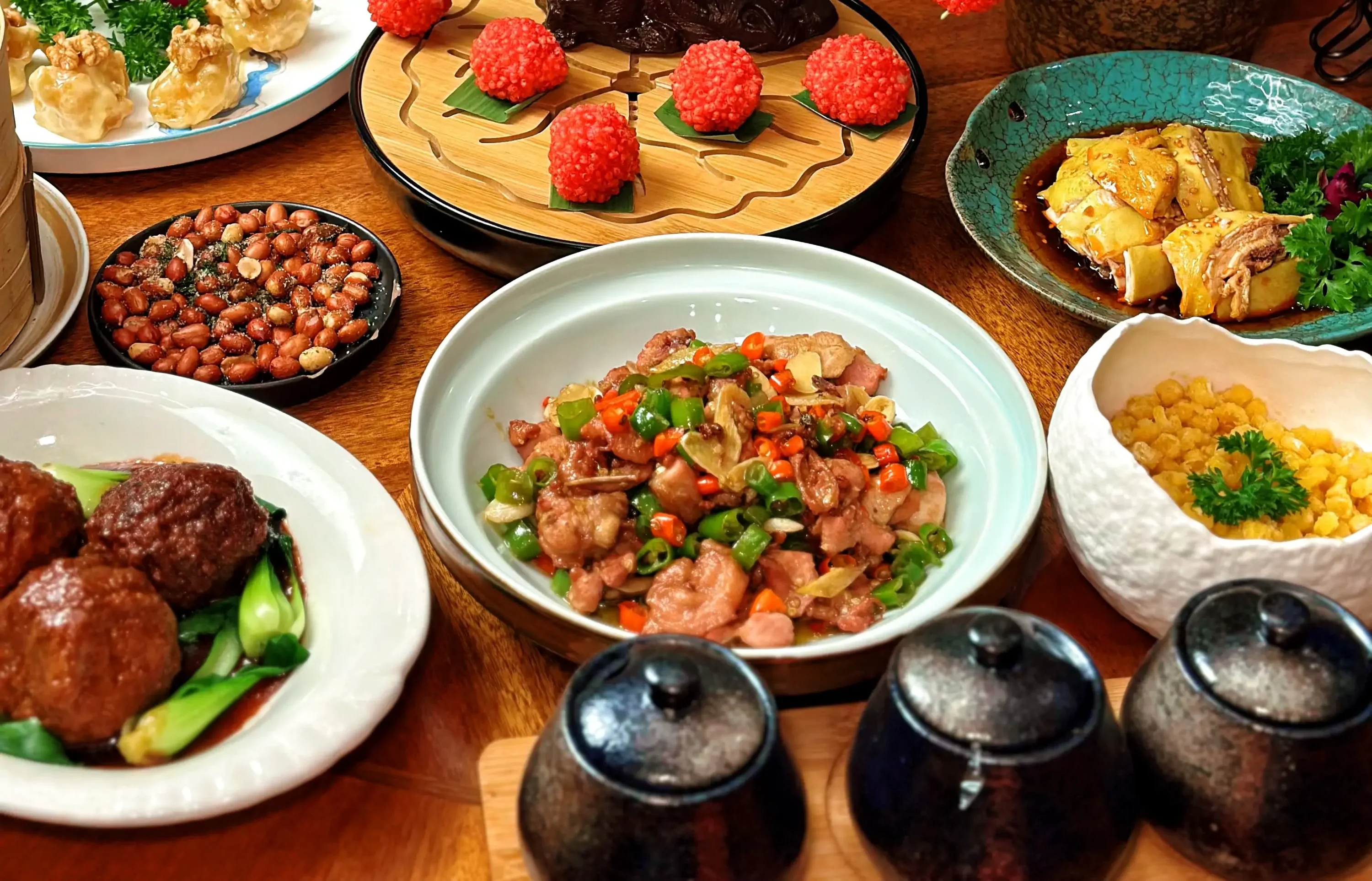 Several plates of food on a wooden table at NYC restaurant Yum Cha