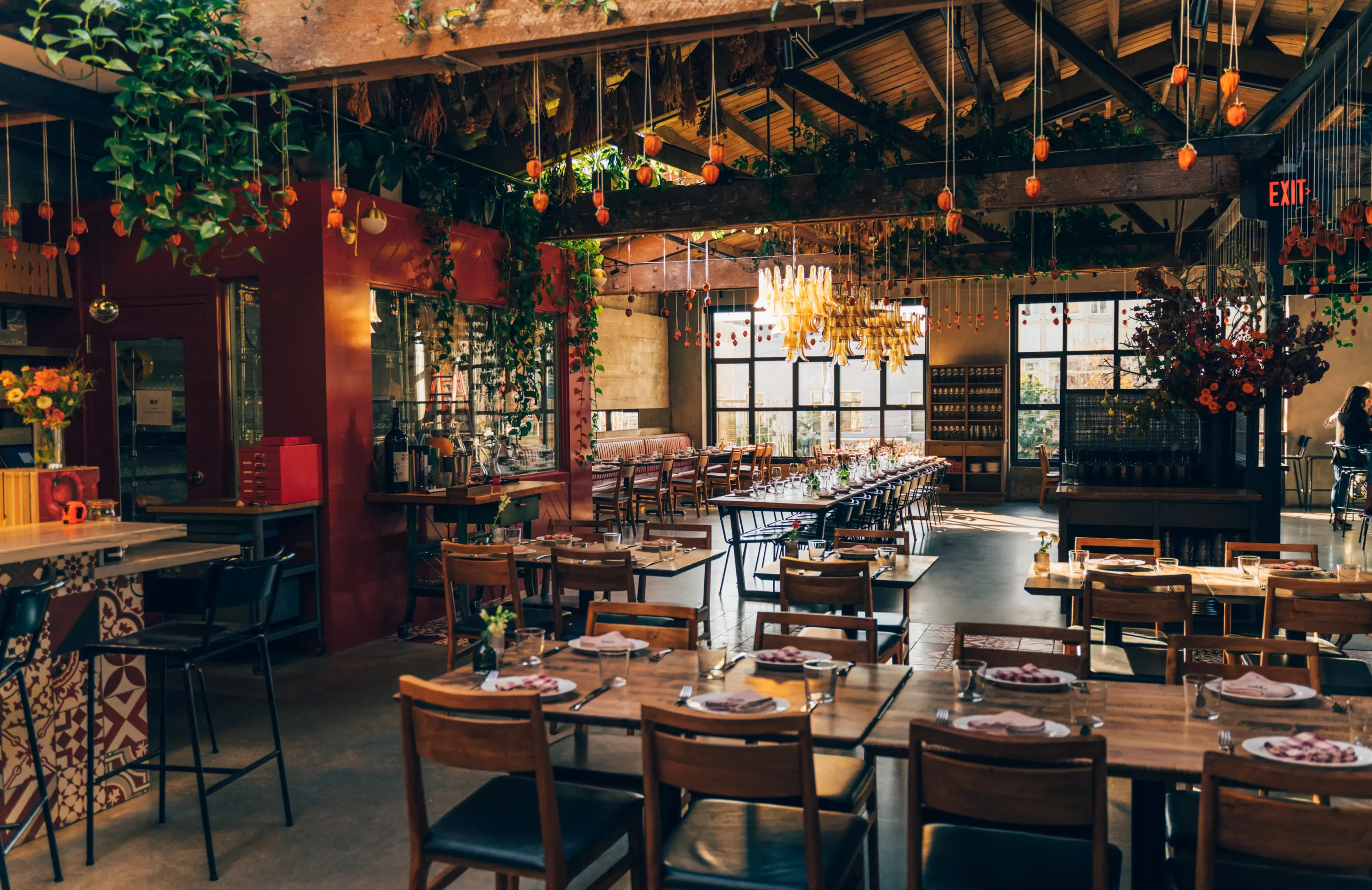 Cozy dark wooden interiors with a large window at Che Fico San Francisco.