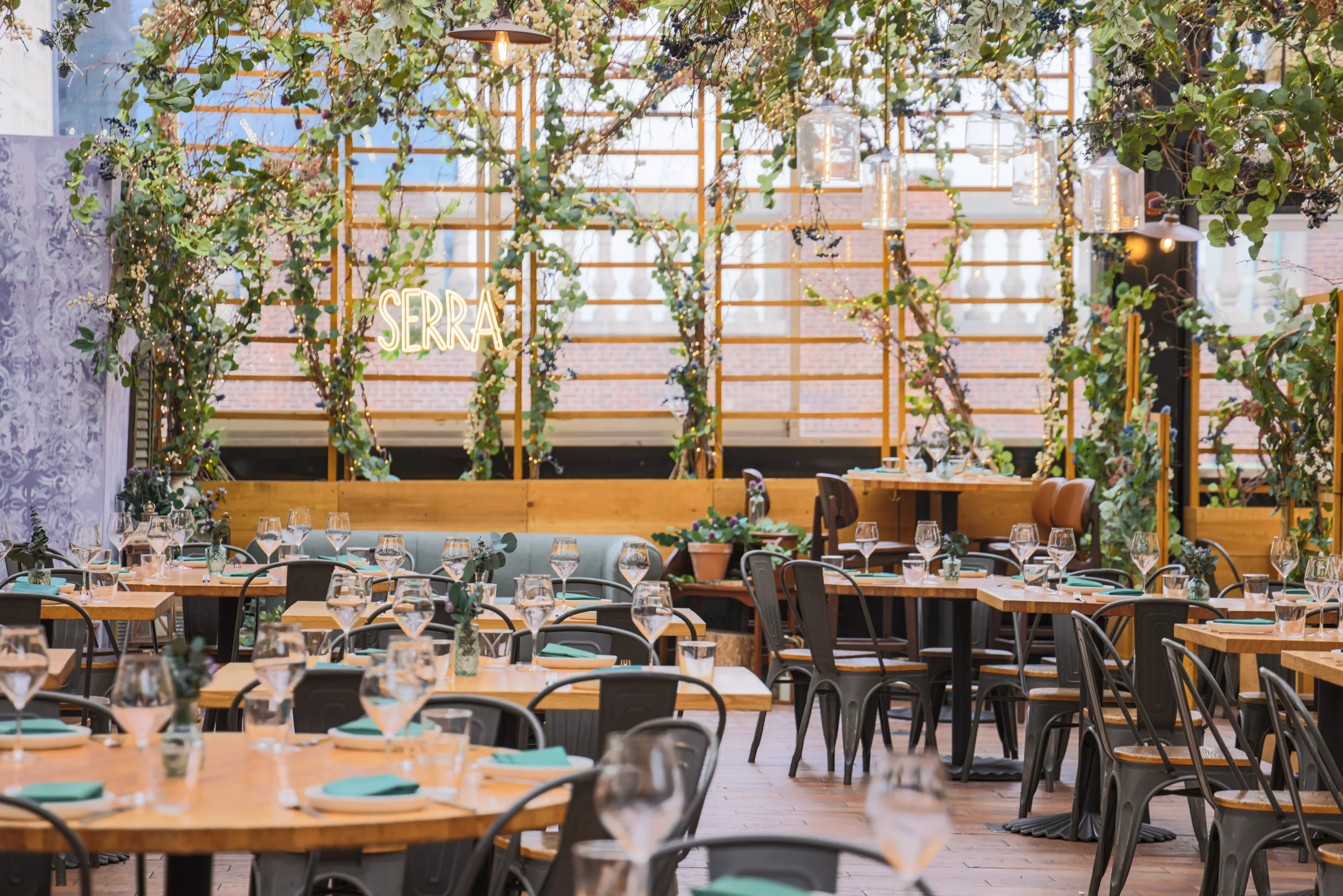 Large windows and plants at Serra by Birreria, one of the best Italian restaurants in New York City. Book on OpenTable.