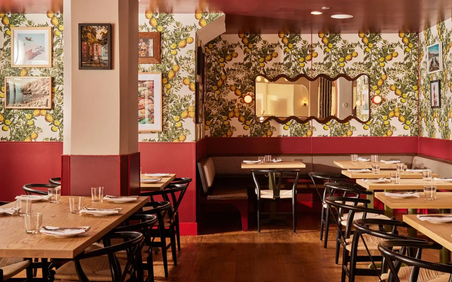 A room with tables and chairs, featuring walls with lemon vines and retro decor at Corzetti in SF. Available on OpenTable.