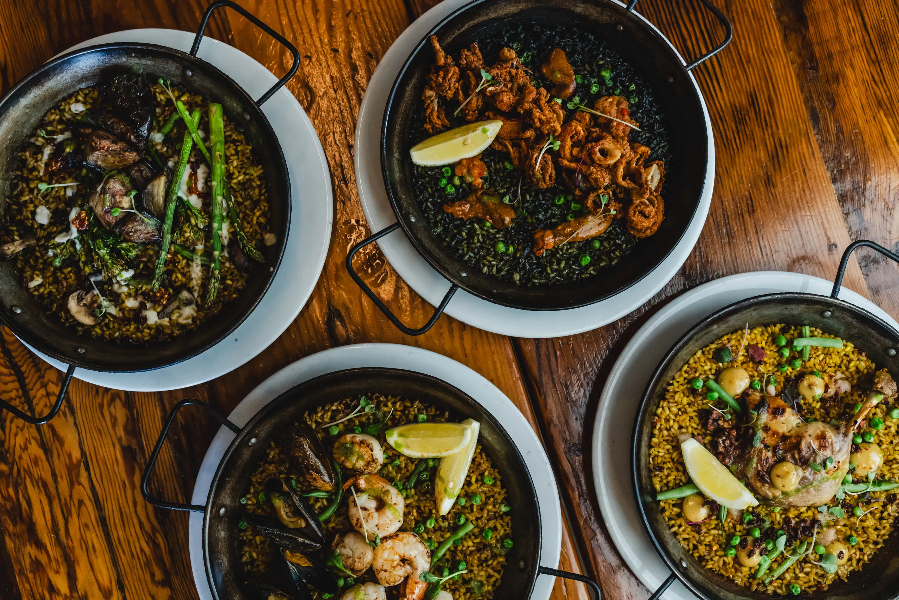 Four bowls of paella at El Raval. Book on OpenTable.
