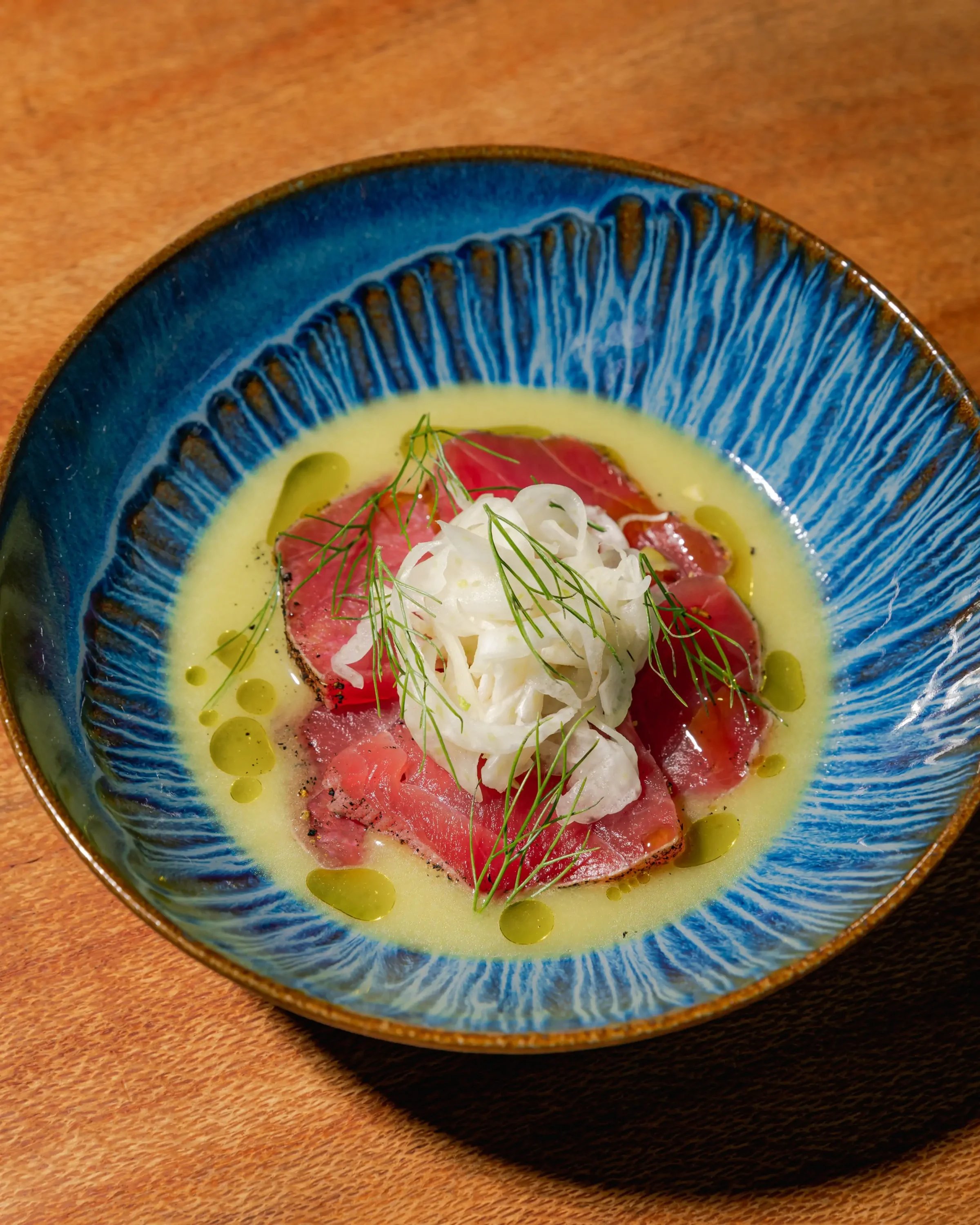 A bowl filled with raw bluefin tuna topped with spring garlic and fennel at Itria in San Francisco. Book on OpenTable.