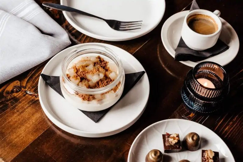 A table with a flickering tealight, cup of sipping chocolate, plate of assorted truffles, and other desserts at Intero in Austin. Available on OpenTable.
