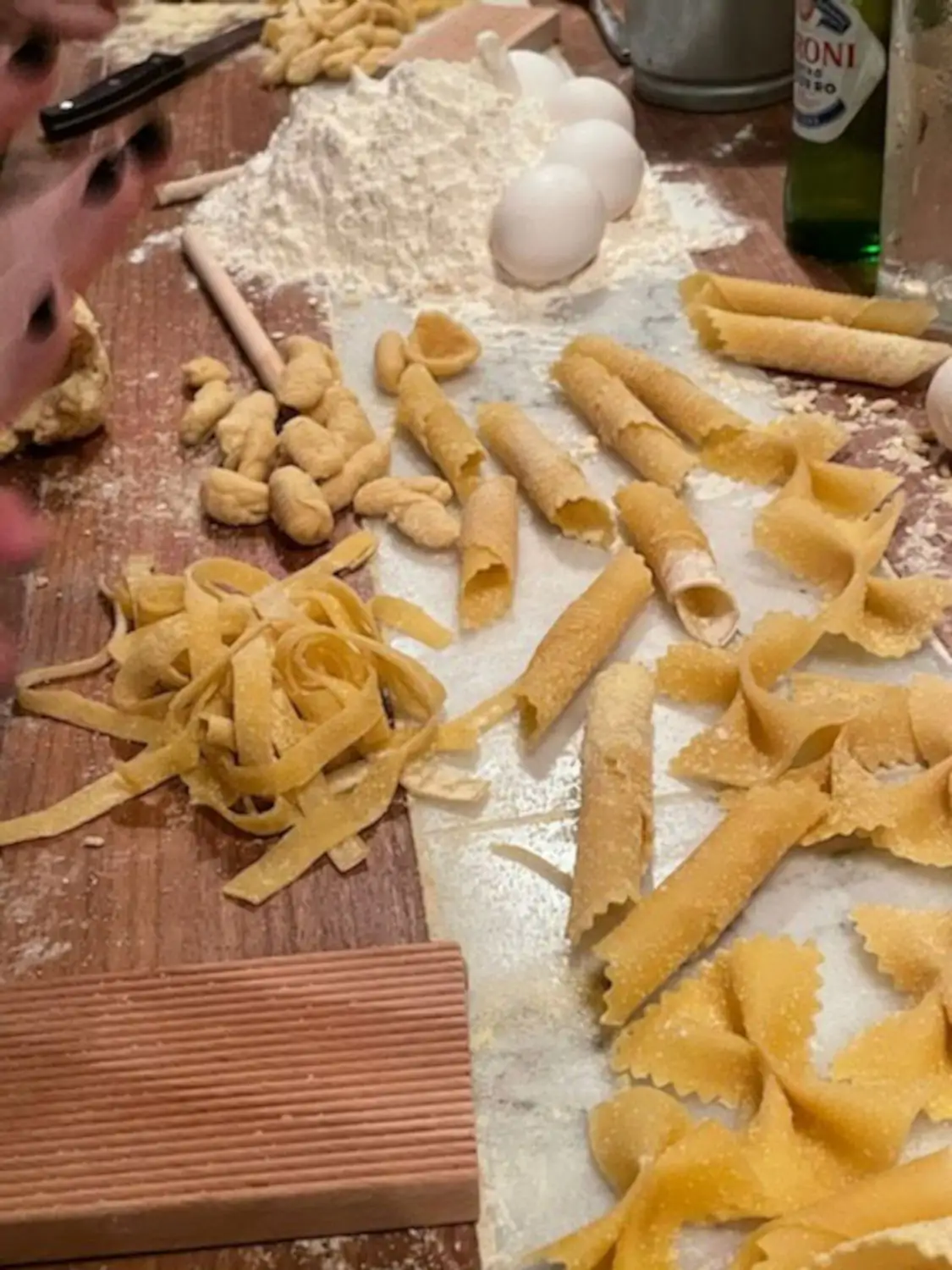 A table with flour, eggs, and various pasta shapes at Aunt Jake's Pasta Experience, one of the best Italian restaurants in NYC. Book on OpenTable.