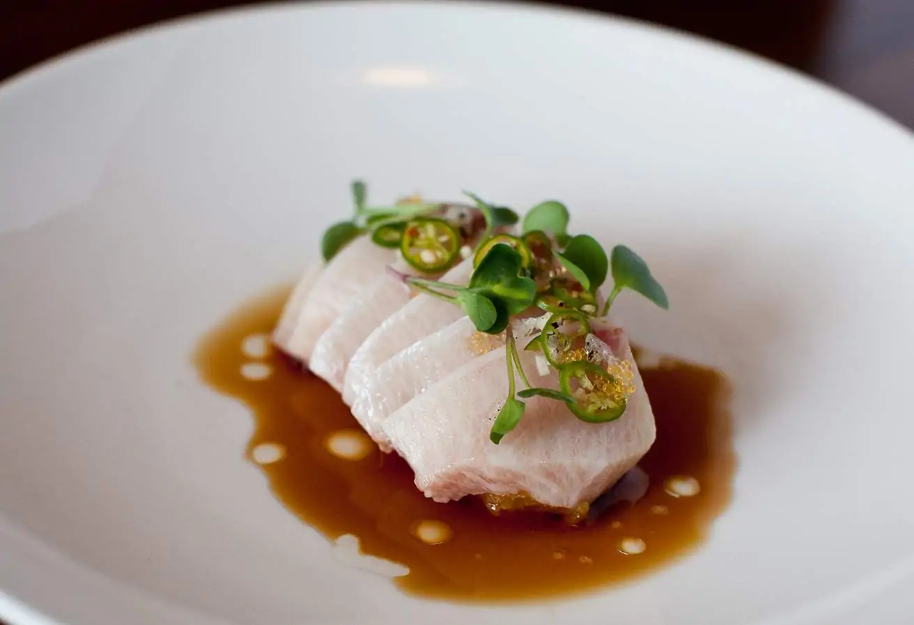 Sashimi garnished with jalapeño slices and micro greens at Uchiko Austin. Book on OpenTable.