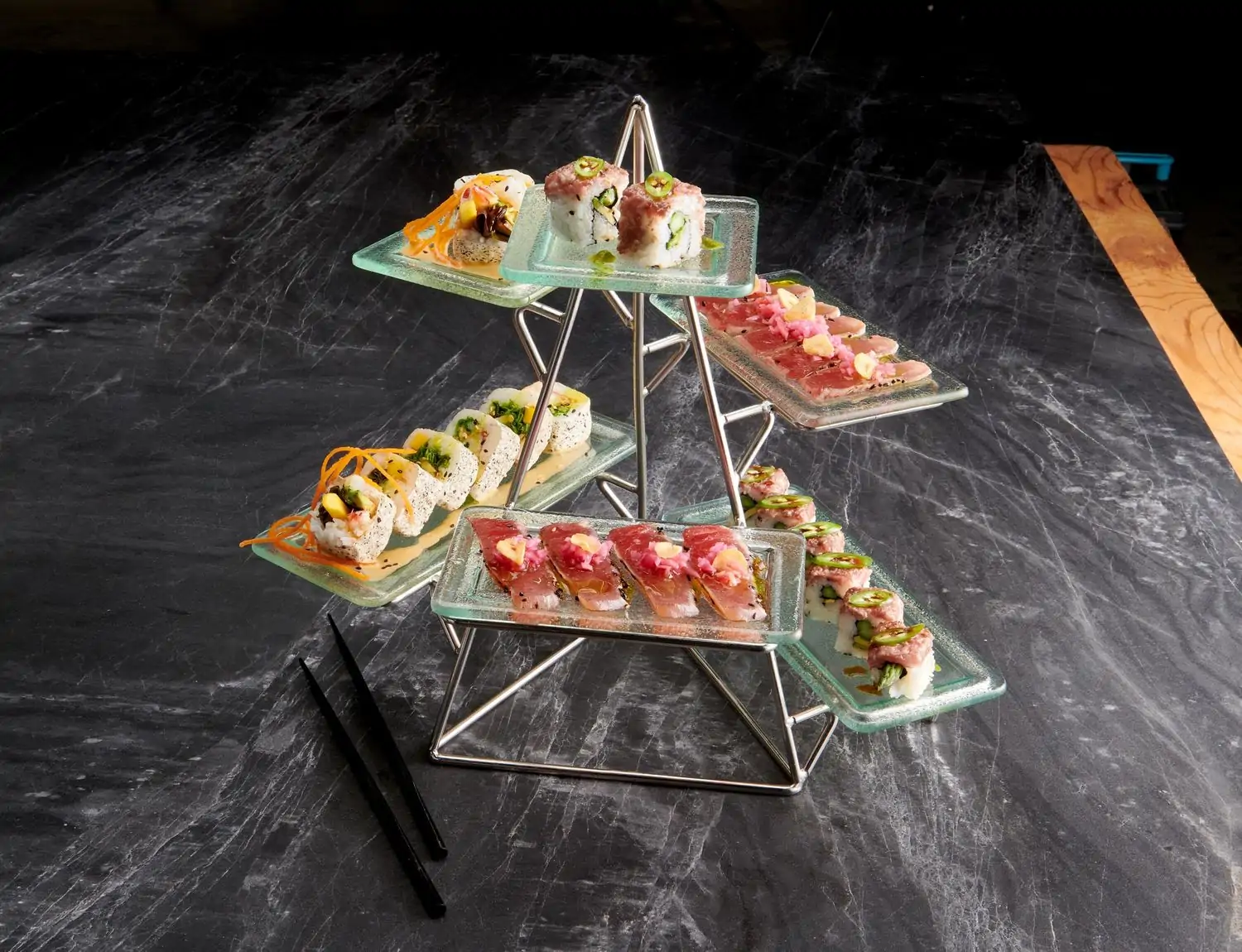 A display of different types of sushi rolls on a table with a pair of black chopsticks on the side at Mastro’s Steakhouse, one of the best Los Angeles Beverly Hills restaurants.