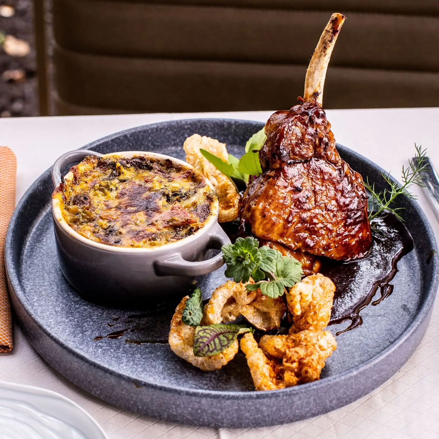 Grilled meat and a dip with fried sides with herb garnishes at Carillon Restaurants, one of the nice restaurants in Austin. Book on OpenTable.
