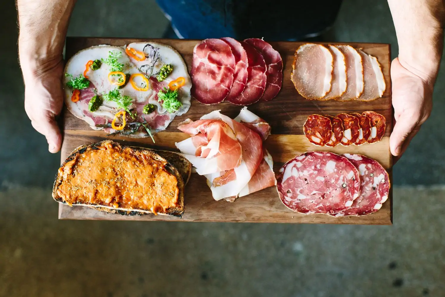 A charcuterie board with different meats on a wooden board at Bestia, one of the best Italian restaurants in LA. Book on OpenTable.
