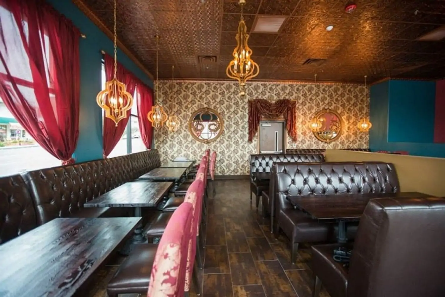 Patterned wallpaper, a textured panel ceiling, dark espresso faux leather booths, and bazaar-inspired chandeliers make up the dining room at Mint Leaf Indian Cuisine, one of the best Indian restaurants in Los Angeles available to book on OpenTable.
