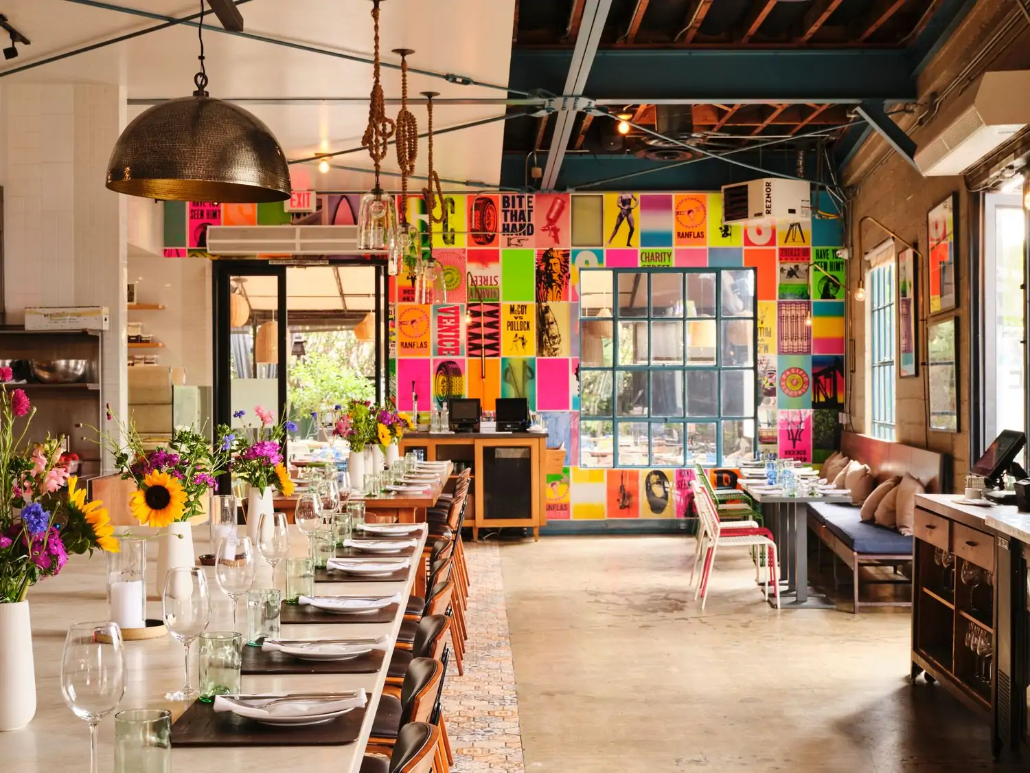 The bright interior of The Rose Venice includes a fluorescent collage and long tables with colorful flowers for community-style eating. This OpenTable restaurant is one of the best restaurants in Venice, Los Angeles.