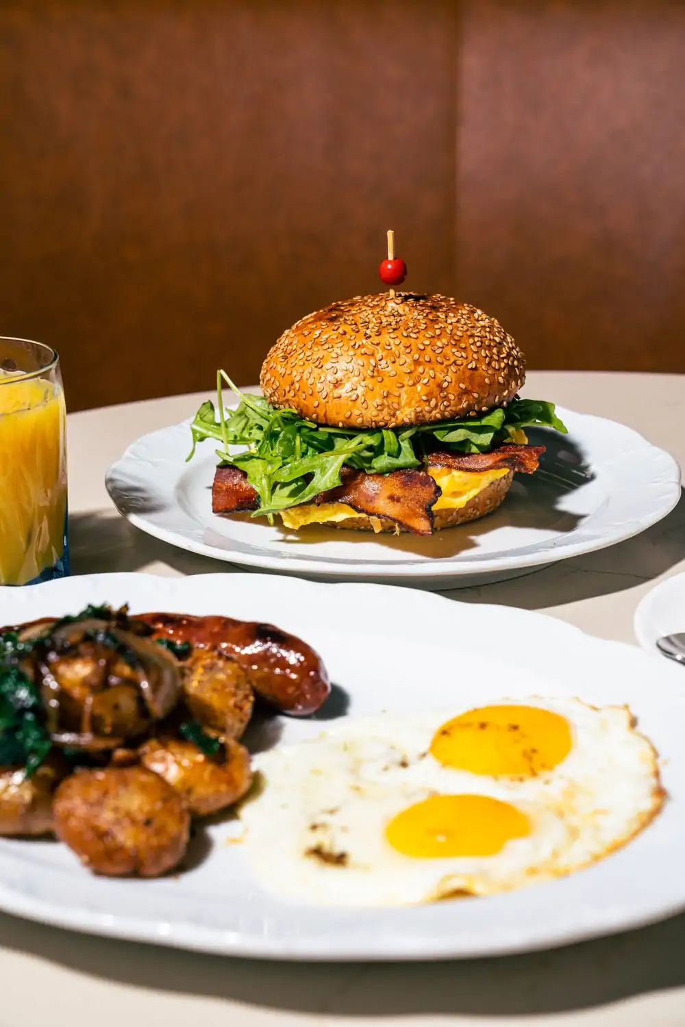 Eggs sunny-side up, a breakfast sandwich, and a glass of orange juice at Rosalie in Dallas, bookable at OpenTable.