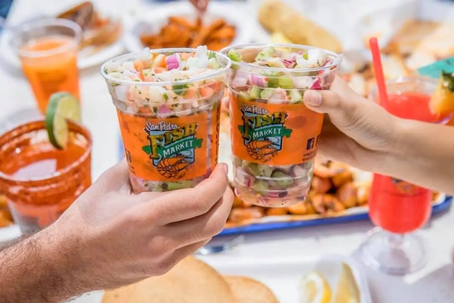 Two plastic cups filled with Campechana, a sharable seafood dish with shrimp, octopus, scallops, cilantro, and red onion at San Pedro Fish Market Long Beach, in Los Angeles, on OpenTable.