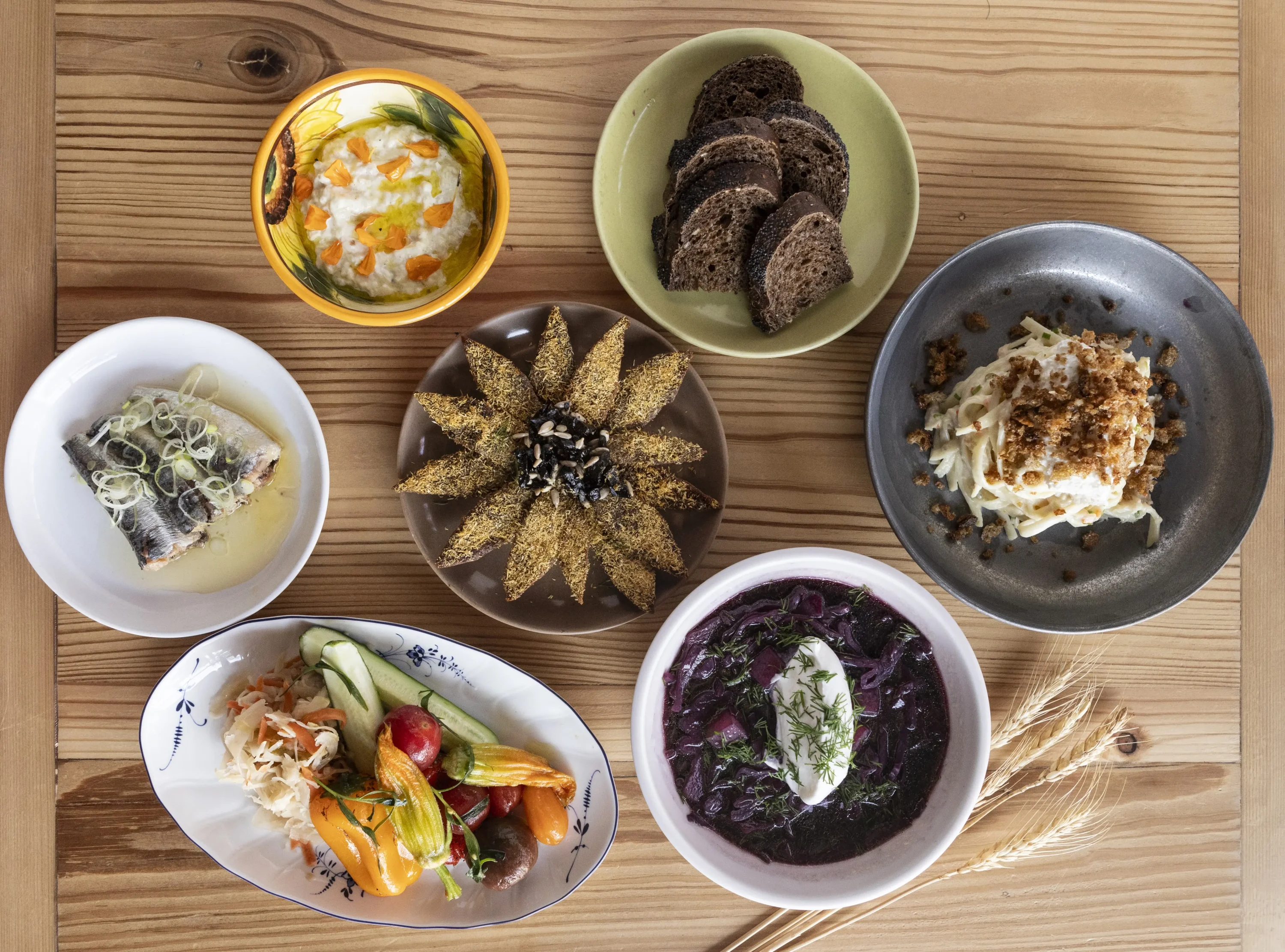 A table setting containing plates of bread, pasta, fish, soup, veggies, and shareable dishes at Anelya, one of the best restaurants in Lincoln Park, Chicago, IL, that you can find on OpenTable.