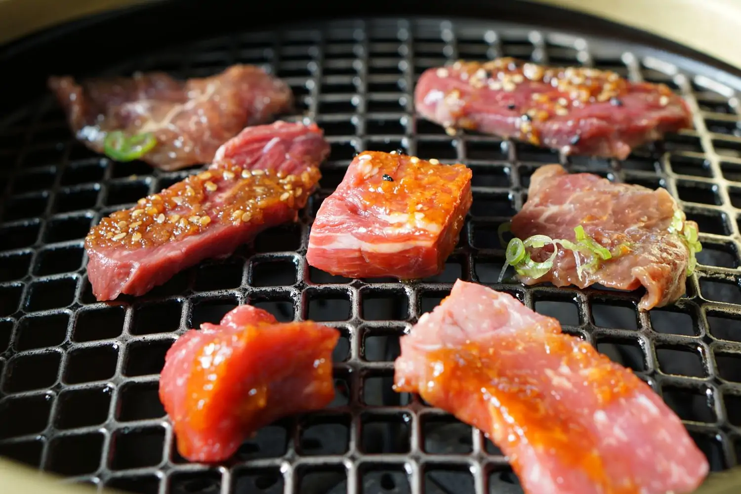 A metal yakiniku-style grill with marbled cuts of beef and pork at Niwa Japanese BBQ, a Dallas restaurant available via OpenTable.