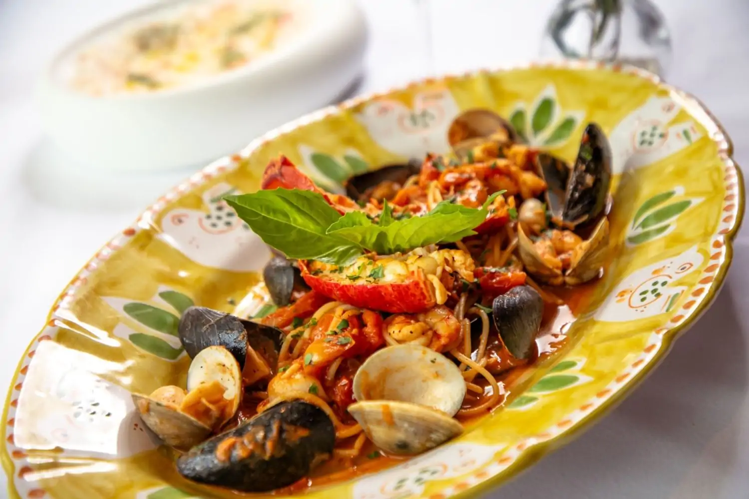 A plate of spaghetti nestles clams and mussels in the shell, a lobster tail, and other morsels of seafood at one of the best Italian restaurants Houston has to offer, Lombardi Cucina Italiana – Houston in Westside, an OpenTable selection.