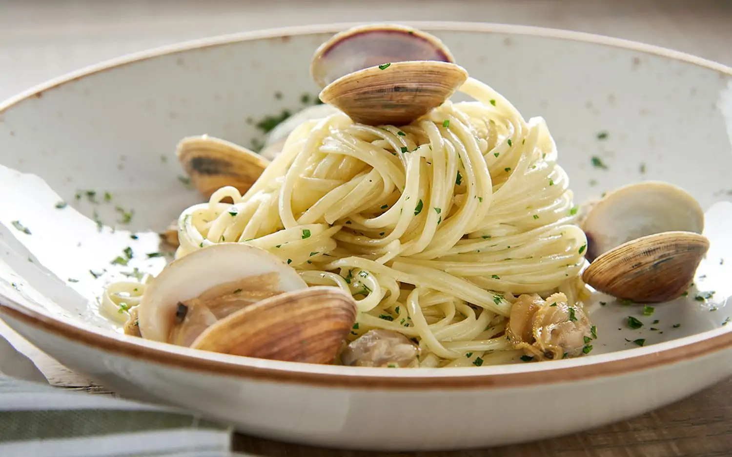 A white plate with spaghetti alle vongole at Zucca, one of the best Italian restaurants in Miami, is available via OpenTable.
