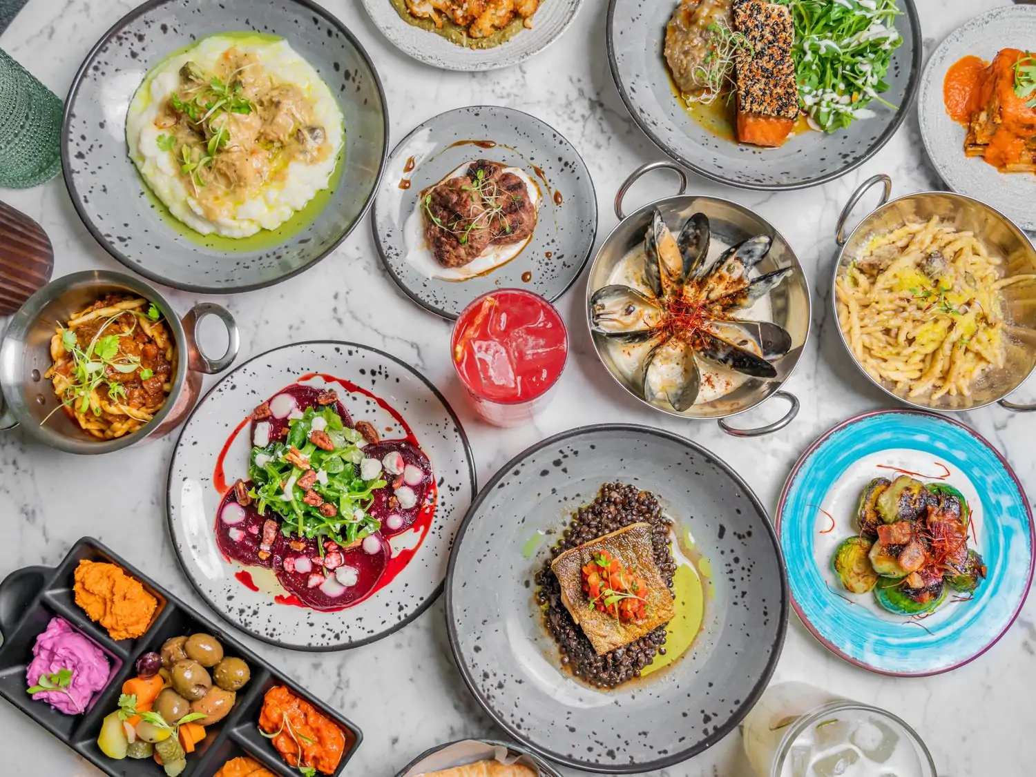 Ceramic platters with kebabs, dips, mussels, Brussels sprouts, and other Mediterranean food at Ambar in Chicago on OpenTable.