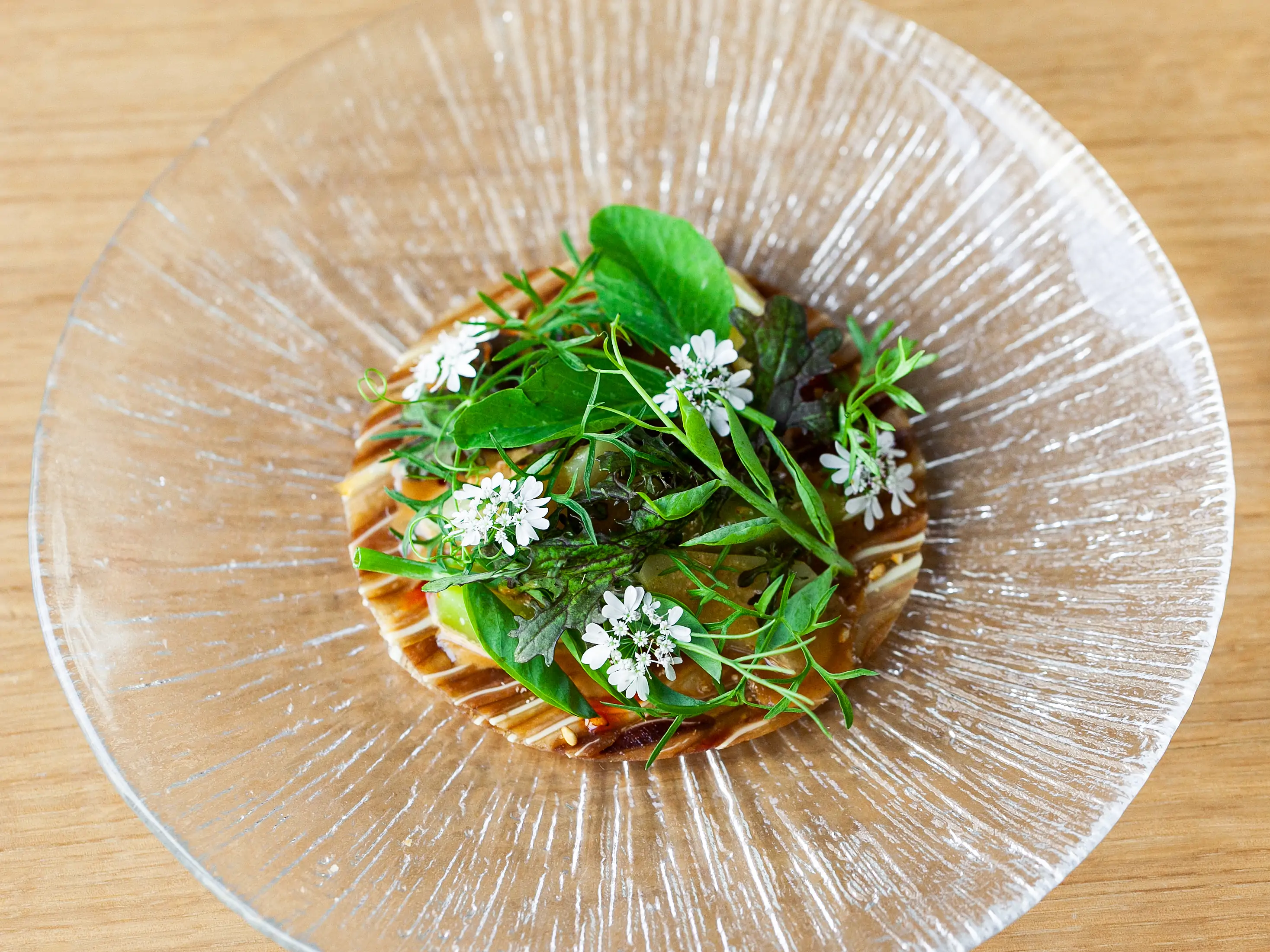 An elegantly plated food dish with edible flowers at Los Angeles restaurant Kato