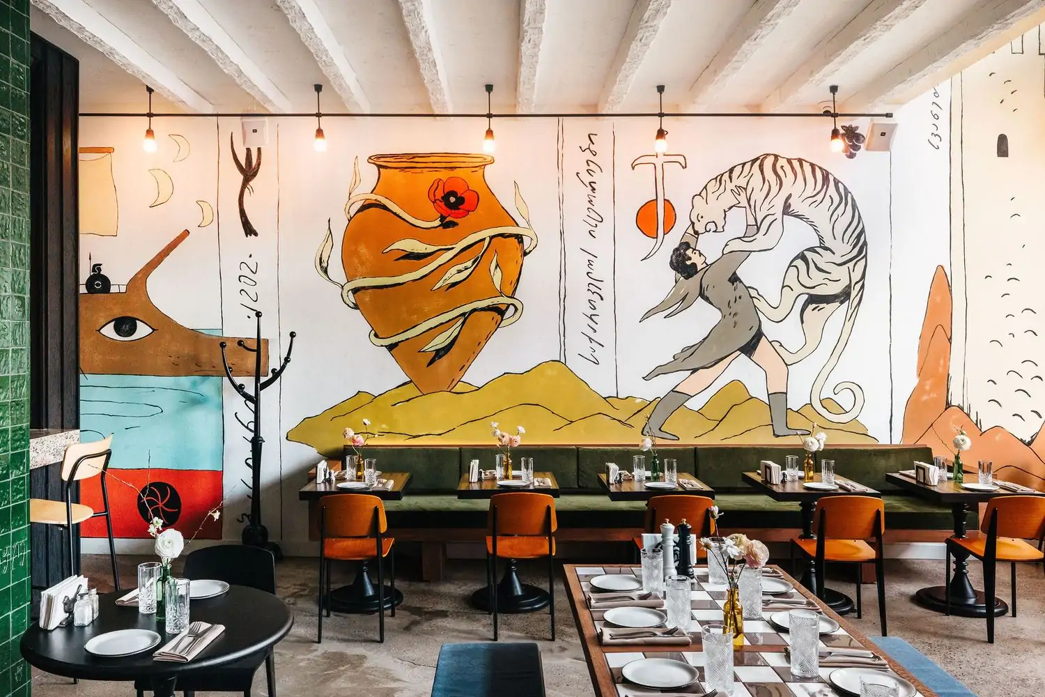 A colorful mural of a man and a tiger and a large heart in a room with tables for two and floral arrangements at Laliko, one of the best new restaurants in NYC on OpenTable.