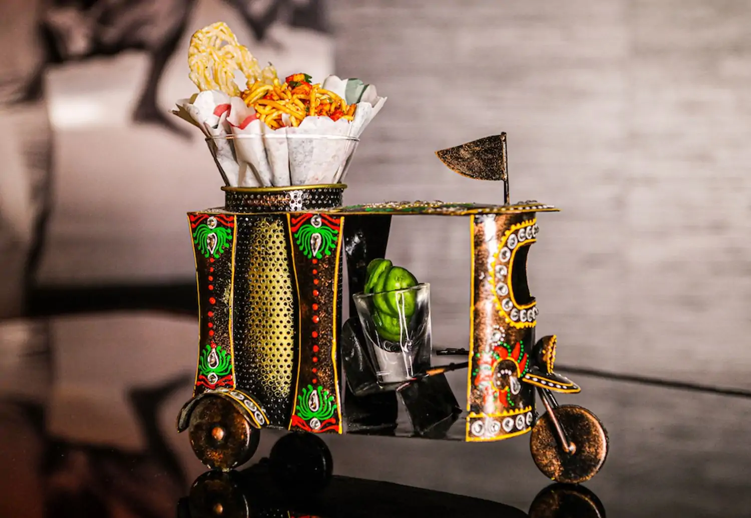 A replica tuk-tuk holding a bowl of crispy fried noodles and slices of green chili at Vermilion, one of the best Indian restaurants in Chicago, on OpenTable.