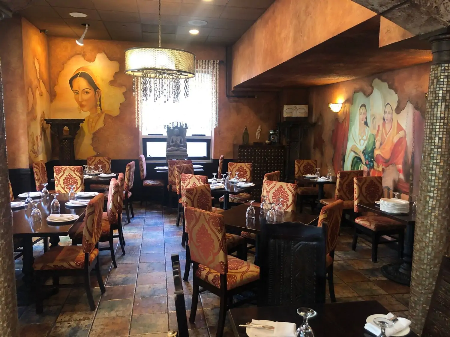 A dining room with murals of Indian women and tiled columns at The India Garden,, one of the best Indian restaurants in Chicago on OpenTable.