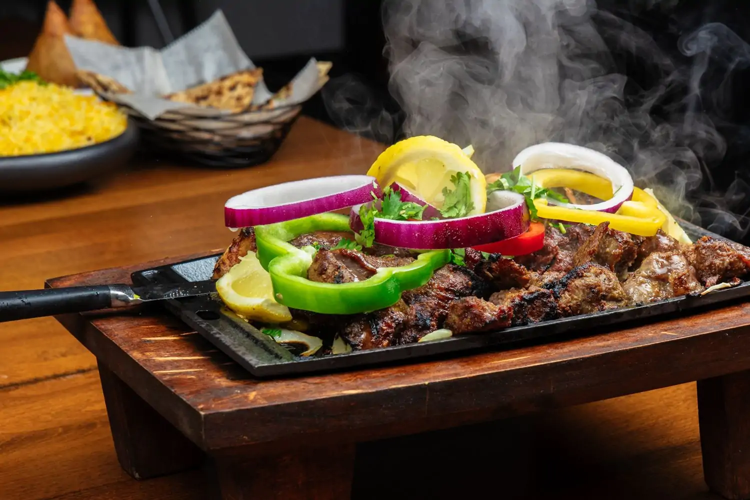 A steaming metal tray stacked high with grilled lamb and chicken at Tandoor Char House, a restaurant in Chicago on OpenTable.