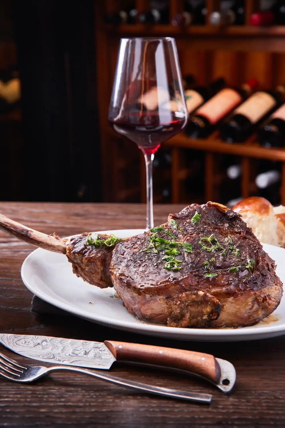 An uncut tomahawk steak with a generous pour of red wine at The Vault Steakhouse, one of the best steak restaurants in San Francisco on OpenTable.