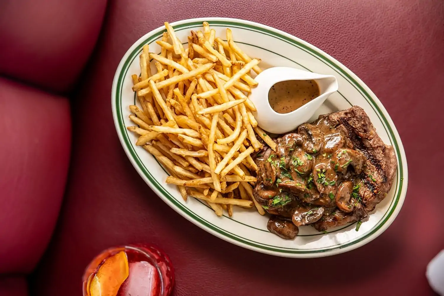 An aged steak paired with thin fries and covered in mushrooms and brandy peppercorn sauce at Steakyard, one of Dallas’s best steak restaurants on OpenTable.