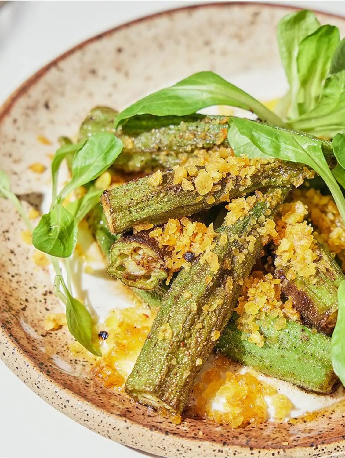 An okra appetizer from Comfort Kitchen, one of the best vegetarian restaurants in Boston, on OpenTable. The okra is topped with crispy plantain crumbs and fresh greens.