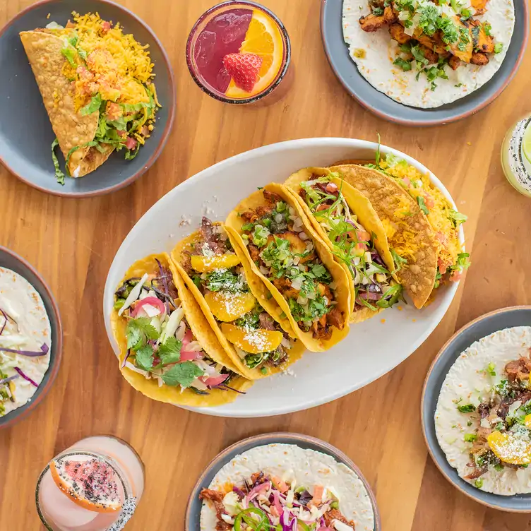 A table covered with Mexican dishes on a variety of plates and dishware, including tacos in both hard and soft shells, at Blanco Cocina + Cantina in Houston on OpenTable.